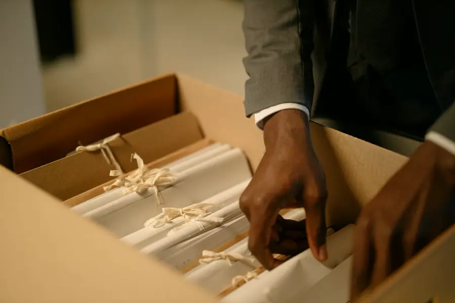 Persona archivando documentos administrativos en una caja