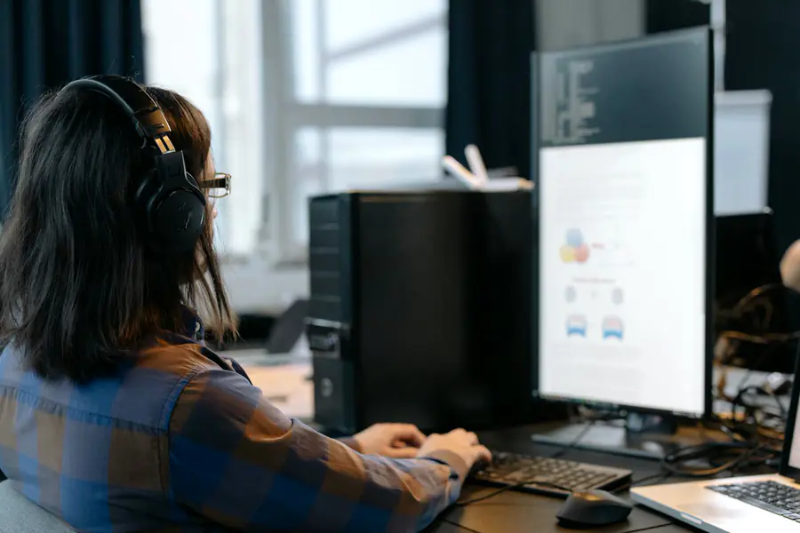 Persona con auriculares atendiendo clientes frente a la pantalla